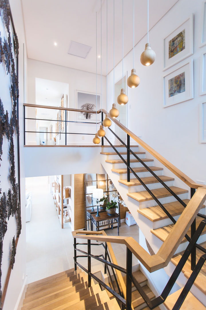Drewniane schody, poręcze i lampy - klatka schodowa w domu
