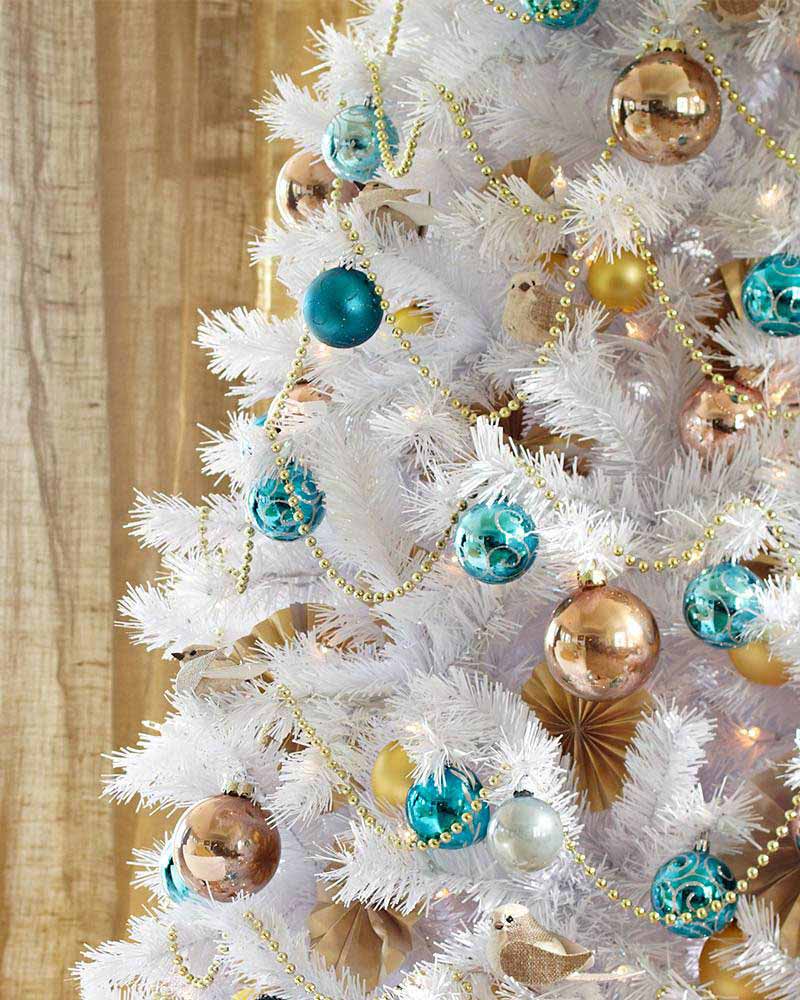 Dwukolorowa dekoracja białej choinki: złote i turkusowe bombki świąteczne